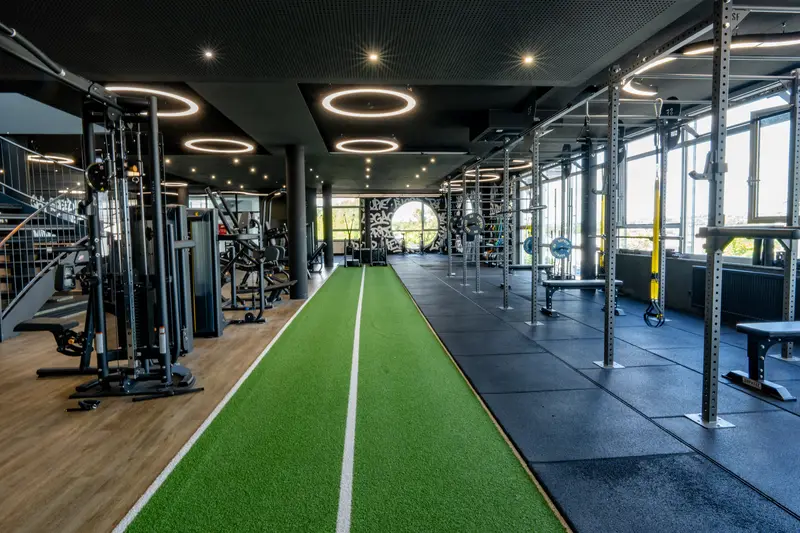 Fitnessbereich mit Kunstrasenbahn und Rigs